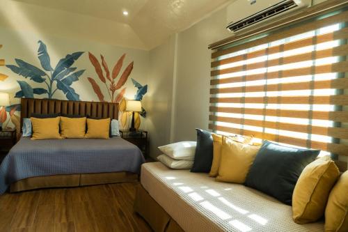 a bedroom with two beds and a couch and a window at Stela Garden Villas in Compostela