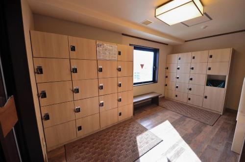 a locker room with wooden lockers and a window at Dormy Inn Hirosaki in Hirosaki