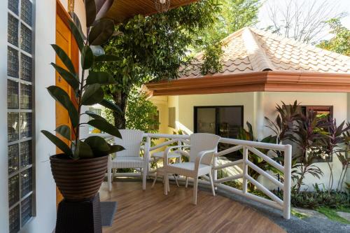 a balcony with chairs and a table on a house at Stela Garden Villas in Compostela
