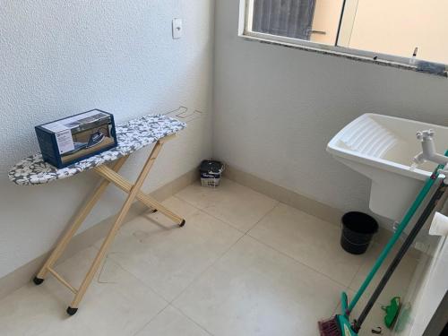 a bathroom with a sink and a table with a box at Apartamento Térreo Talismã 04 in Sinop