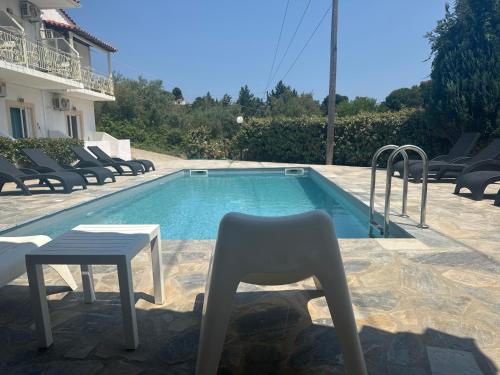 a chair and a table next to a swimming pool at Esperos Apartments&Studios in Troulos