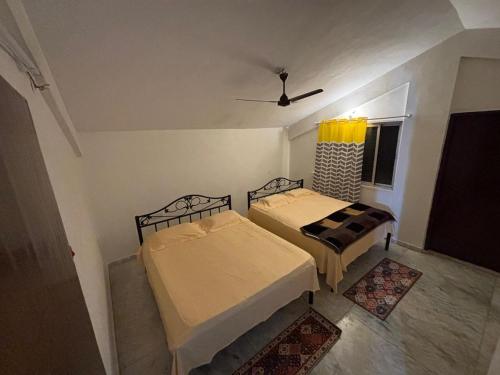 two beds in a small room with a window at Spacious 3 BHK Villa, Lonavala in Lonavala