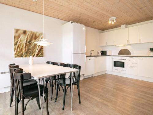 a kitchen and dining room with a table and chairs at Ho Holiday Center in Blåvand