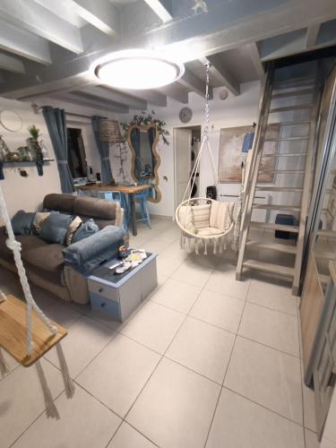 a living room with a couch and a swing at Le Blue Dream Arcade Bain à bulles in Ladon