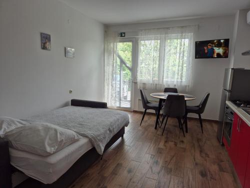 a bedroom with a bed and a table and chairs at Apartmani Hršak in Krapina