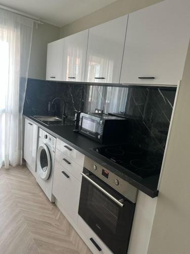 Il comprend une cuisine équipée d'un four micro-ondes et de plaques de cuisson. dans l'établissement Moderne Appartement Strasbourg, à Strasbourg