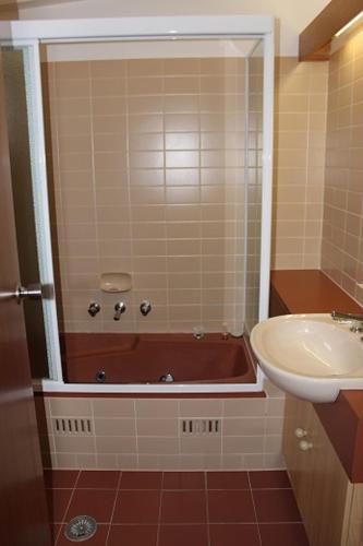 un baño con bañera y lavabo en Boonoona Ski Lodge, en Perisher Valley