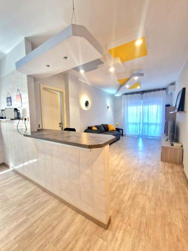 a large living room with a kitchen with a bar at Terrace between Rome and the sea in Vitinia