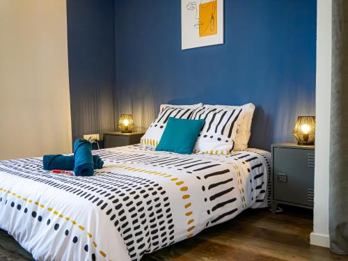 une chambre avec un grand lit blanc avec des murs bleus dans l'établissement Immeuble complet Casa Bella & Divina, à Thiers