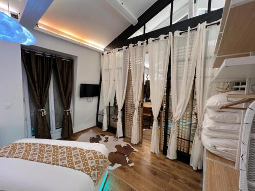 une chambre avec des rideaux blancs et un lit dedans dans l'établissement Appartement haut standing 3 pieces, à Paris