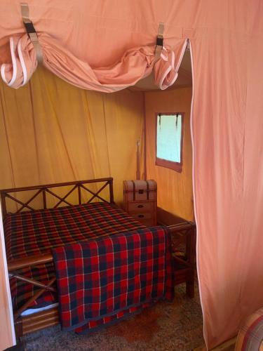Un dormitorio con una cama en una tienda de campaña. en Tente Lodge en pleine nature, en Cros