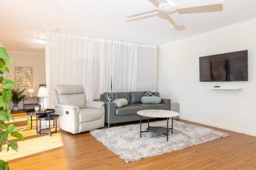 a living room with a couch and a chair at Guest Suite in Duffy with Pool View in Weston Creek