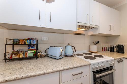 a kitchen with white cabinets and a counter top at Guest Suite in Duffy with Pool View in Weston Creek