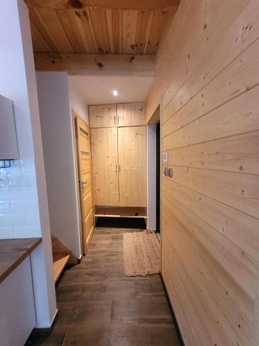 a hallway with wood paneled walls and a kitchen at Bazylówka in Czyże