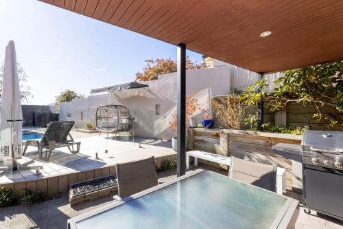 a patio with a swimming pool and a table and chairs at Guest Suite in Duffy with Pool View in Weston Creek