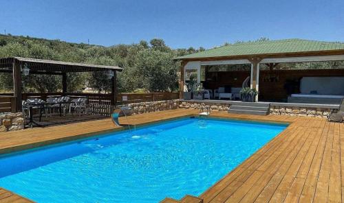 a large blue swimming pool on a wooden deck at גרין פארק - קוטג' מהמם עם בריכה וג'קוזי בעין קנייא in Ein Kinya