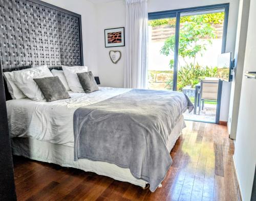 une chambre avec un lit et une grande fenêtre dans l'établissement Villa Mile, à Cannes