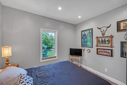 a bedroom with a blue bed and a window at Lakeside Retreat with Hot Tub & Game Room home in Elkhart