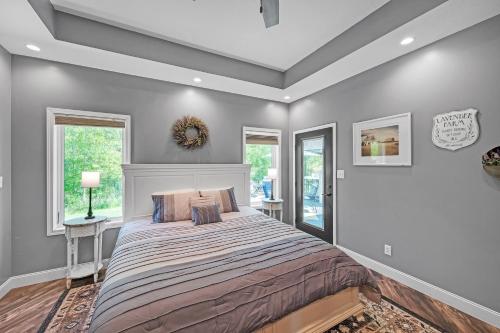 a bedroom with a large bed and two windows at Lakeside Retreat with Hot Tub & Game Room home in Elkhart