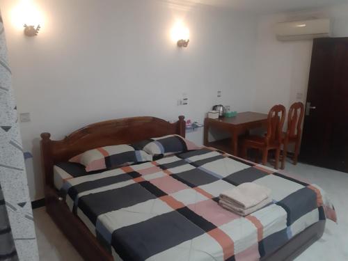シェムリアップにあるHomestay 1-2pax AC room 1 including private kitchenのベッドとテーブルと椅子のある寝室