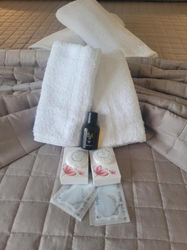 a bed with two towels and a bottle of perfume at Fly to Venice Airport View locazione turistica in Venice