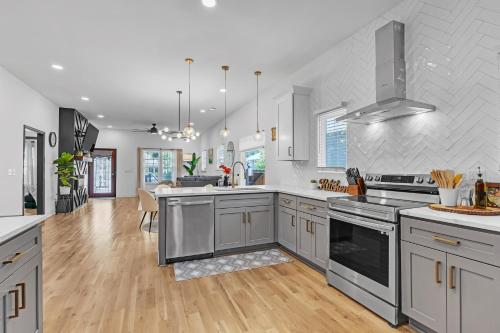 a large kitchen with stainless steel appliances and wood floors at Stylish Bungalow Near BeltLine & Breweries bungalow in Atlanta