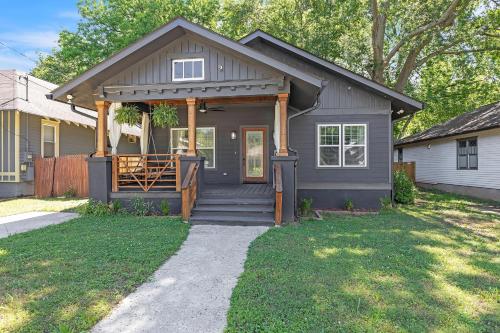a gray house with a porch and a fence at Stylish Bungalow Near BeltLine & Breweries bungalow in Atlanta