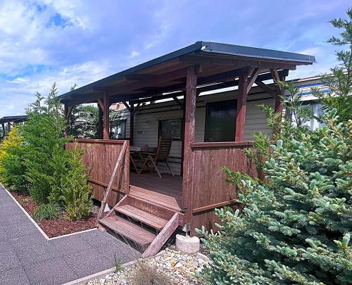 a house with a wooden porch with a bench at Domčeky Nesvady in Nesvady