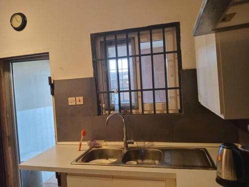 a kitchen with a sink and a window at Travellers Ensuites, La Beach Hub in Trofwi