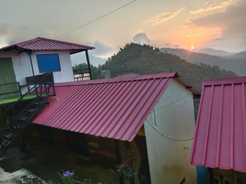 a view of a house with a pink roof at Kanatal vatika and home in Kanatal