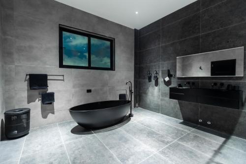 a bathroom with a bath tub and a television at The VVS Apartments in Accra