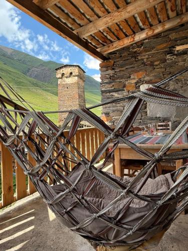 a hammock on the porch of a house with a view at Nizharadze's Tower in Ushguli