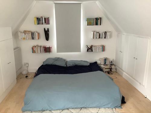 a bedroom with a large bed in a white room at Beautiful flat, 30 min away from central London in Bromley