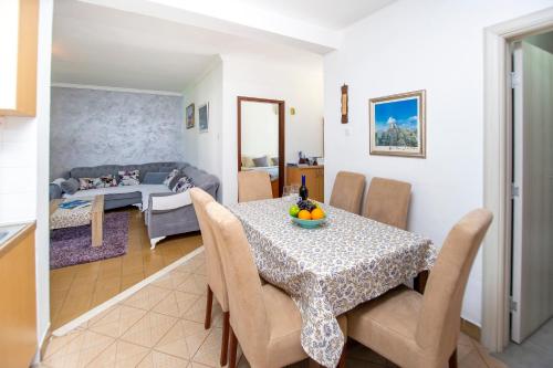 a dining room and living room with a table and chairs at Apartment Stanko in Pržno