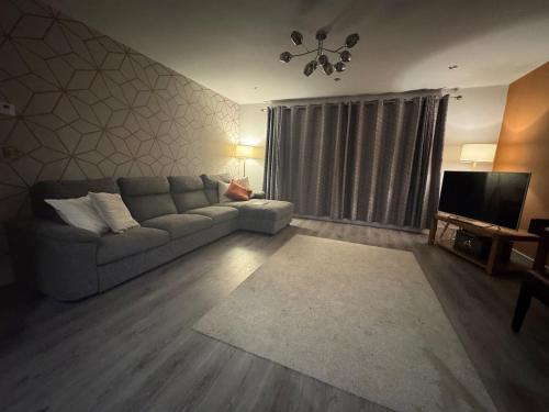 a living room with a couch and a television at Luxury Home by the Sea in Bunbeg
