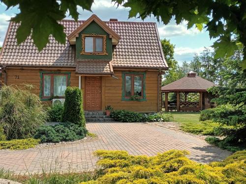 a house with a tiled roof and a brick driveway at Bocianie Siedlisko in Janowo