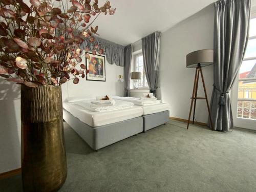 a bedroom with two beds and a vase with flowers at Landgasthof Alter Wirt in Unterschleißheim