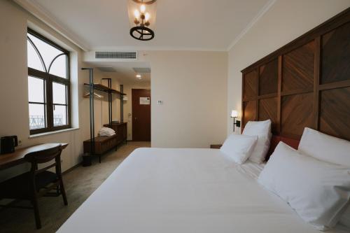 a bedroom with a large white bed and a desk at AGARANI Estate in Tʼelavi