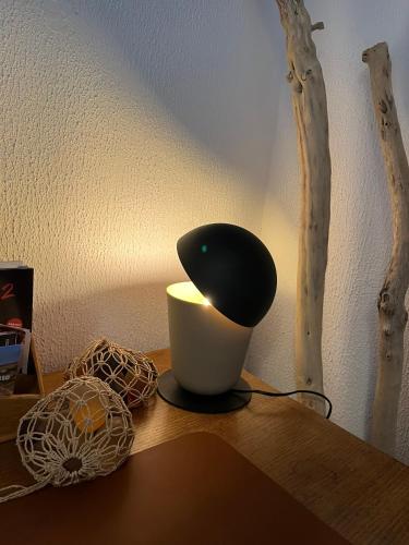 a lamp sitting on top of a wooden table at Les Capucines, comme chez soi, loin de chez soi in Aubenas