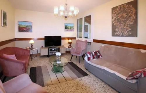 a living room with a couch and a tv at Maison paisible à Veyras avec piscine privée et vue montagne in Veyras