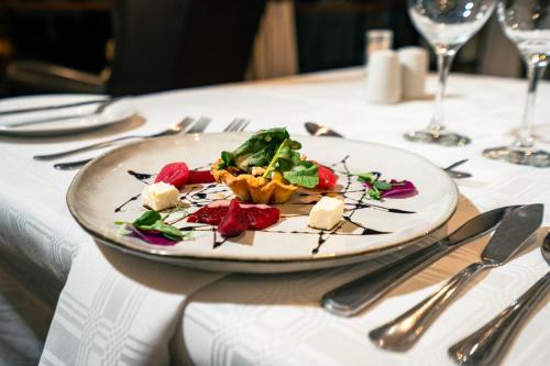 a plate of food on a table with silverware at Budmarsh Country Lodge in Magaliesburg