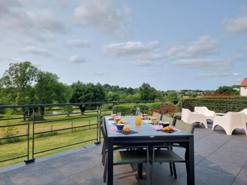 a patio with a table and chairs on a balcony at Villa Albatros, Vue golf imprenable, WIFI, Confort in Nesmy