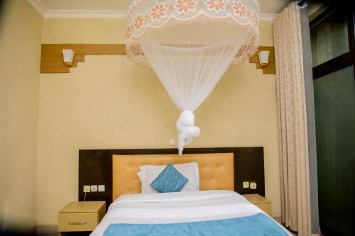 a bedroom with a bed with a chandelier above it at QUALITY INN HOTEL Kigali in Kigali