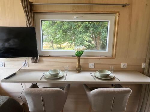 une table dans une petite maison avec une fenêtre dans l'établissement Tiny House, à Corps-Nuds