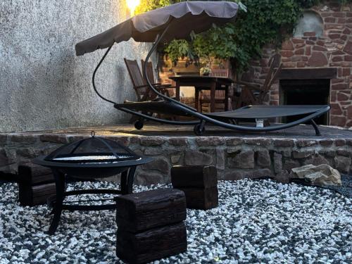 a fire pit with a grill and a table at Living Past Vendégház in Kővágóörs