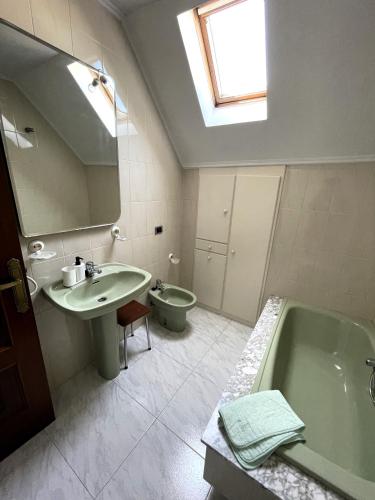 a bathroom with a sink and a tub and a toilet at EnVIVEIRO Villa Bonita in Viveiro