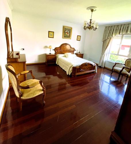 a bedroom with a bed and a table and chairs at EnVIVEIRO Villa Bonita in Viveiro