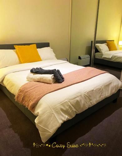 a bedroom with a large bed with towels on it at Cozy Suite in Clayton North