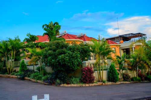 a house with a fence and trees and plants at QUALITY INN HOTEL Kigali in Kigali