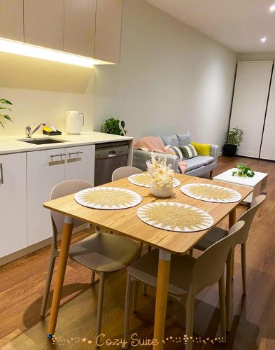 a kitchen and a table with chairs in a room at Cozy Suite in Clayton North